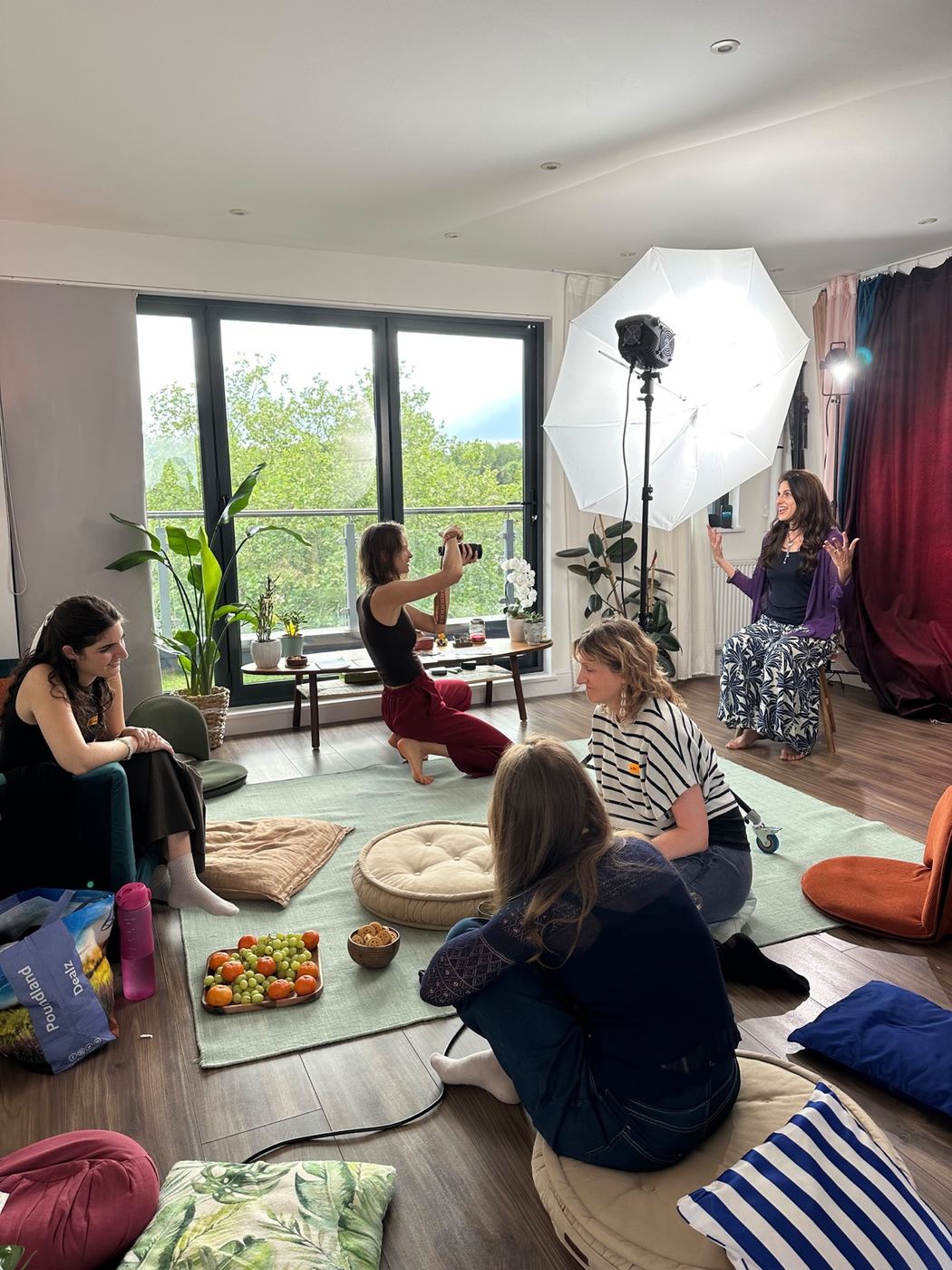 Anasta guiding a participant during a portrait session while the group relaxes nearby
